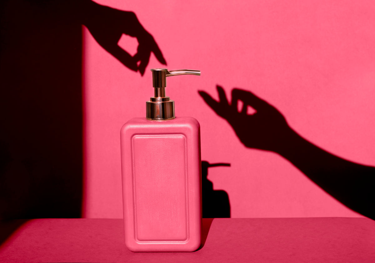 pink-soap-dispenser-shadow-hand-reaching-artistic-2026-03-13-01-57-27-utc.jpg