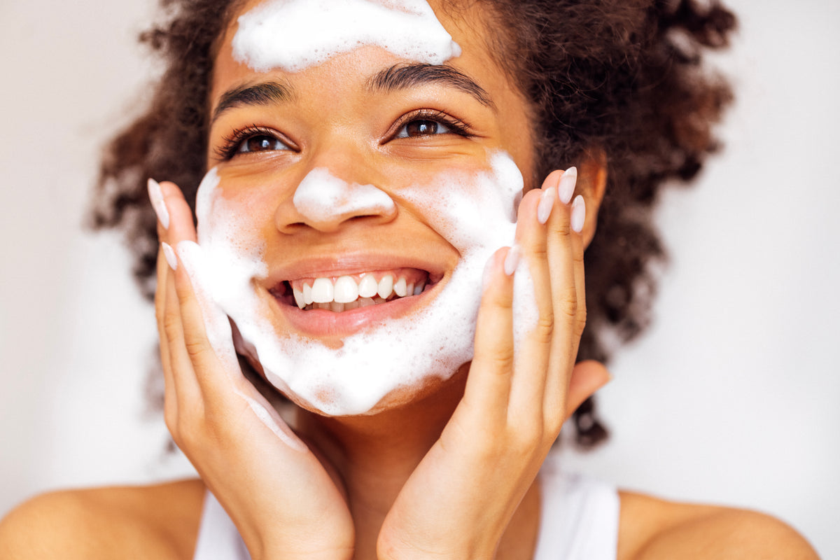 smiling-woman-cleansing-her-face-with-facial-clean-2026-01-07-02-09-32-utc.jpg